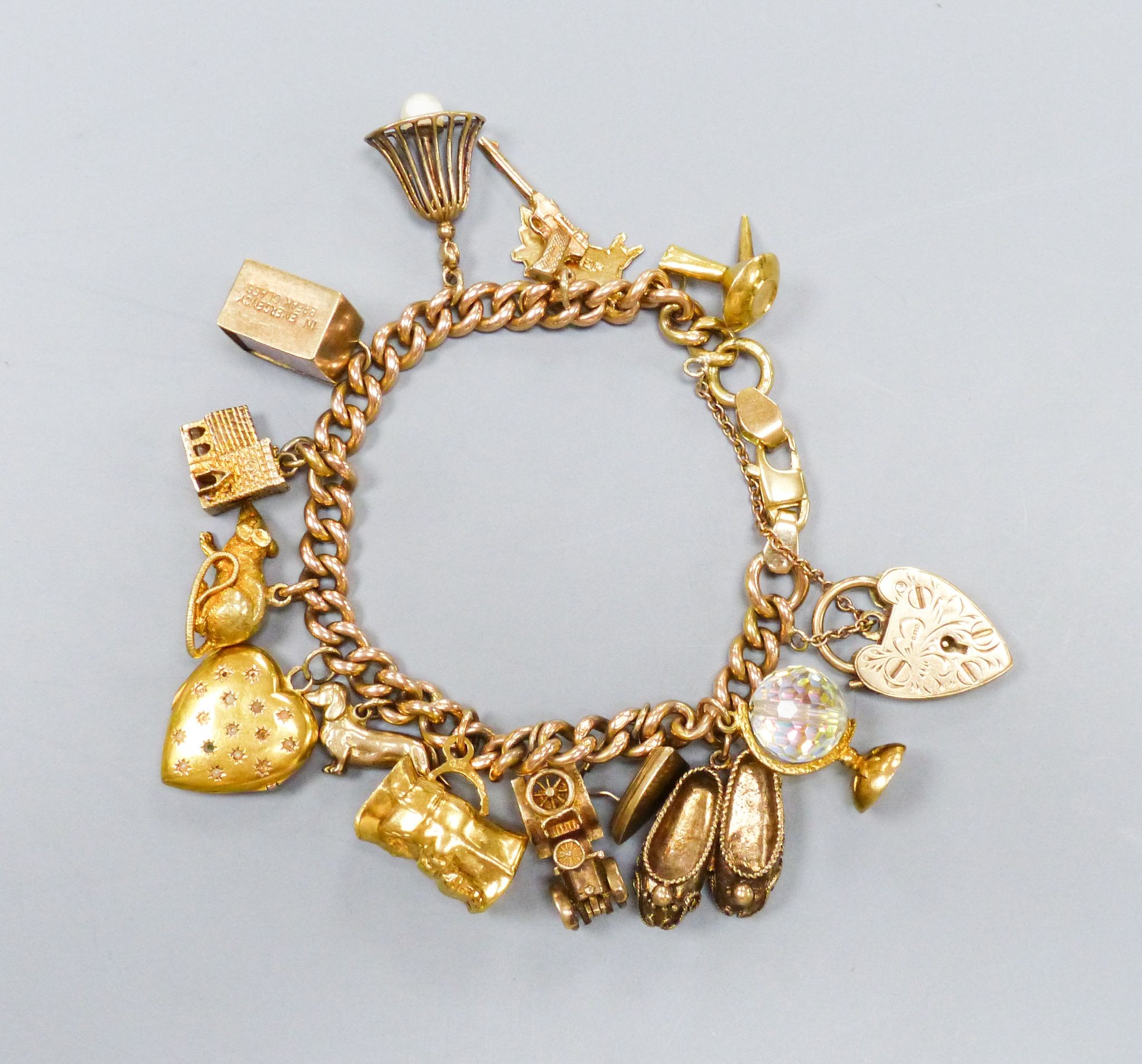 A 15ct rose gold chain charm bracelet, with 9ct and other charms to include animals, a motorcar etc. gross weight 69.0grams.